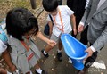 東京都内の小学校で行われた公衆衛生に関する特別授業で、リクシルの簡易トイレ「SATO」を見る児童ら（2018年7月26日撮影）。(c)AFP PHOTO / Kazuhiro NOGI