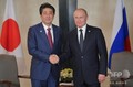 シンガポールでロシアのウラジーミル・プーチン大統領（右）と握手をする安倍晋三首相（2018年11月14日撮影）。(c)Alexey DRUZHININ / SPUTNIK / AFP