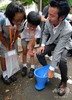 東京都内の小学校で行われた公衆衛生に関する特別授業で、リクシルの簡易トイレ「SATO」を見る児童ら（2018年7月26日撮影）。(c)AFP PHOTO / Kazuhiro NOGI